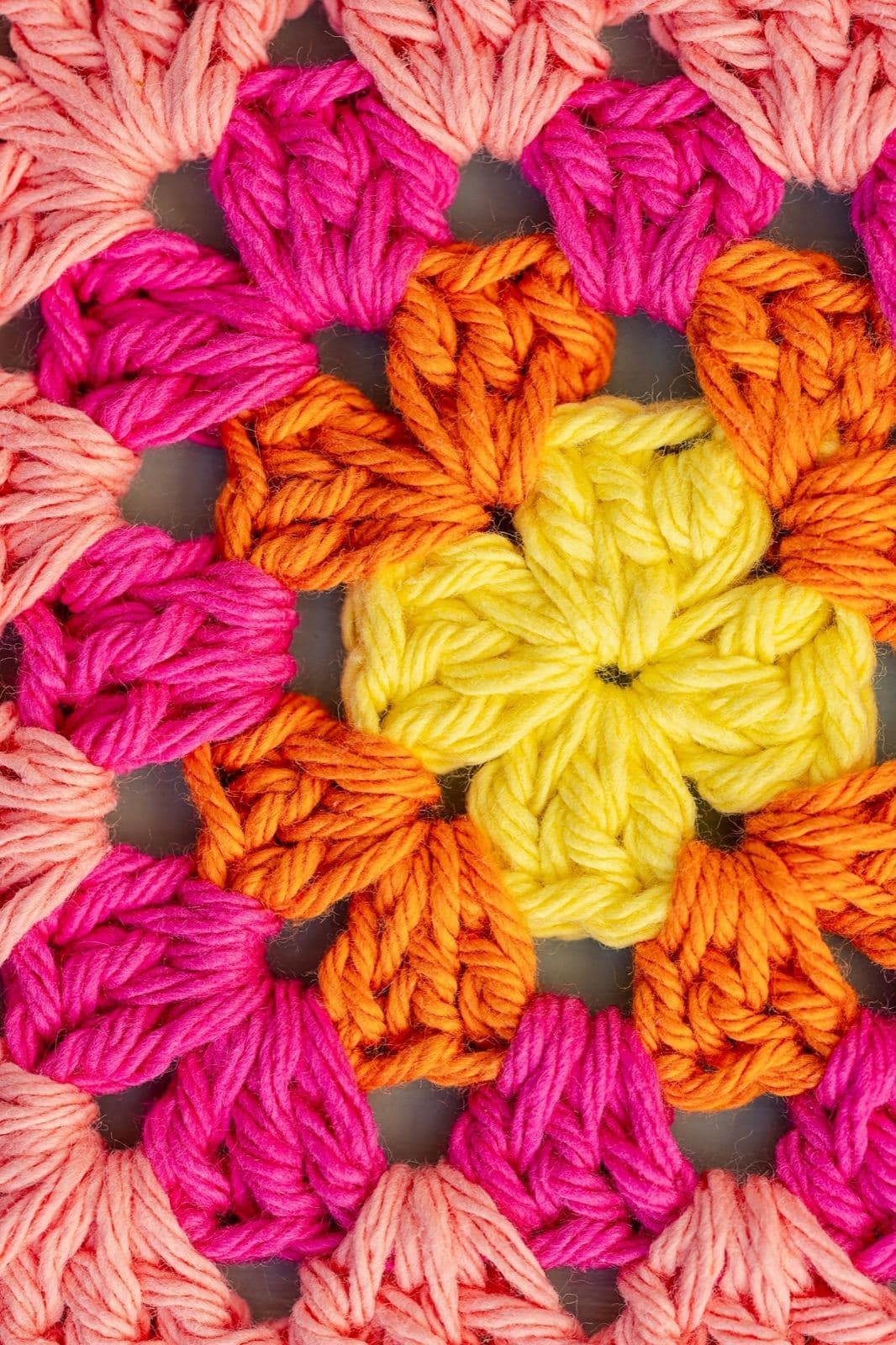 Close-up of a bright crochet granny square in yellow, orange, and pink (inspiration photo by another maker, not made from this pattern)